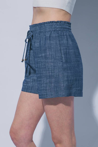 Blue denim skirt worn by a person on a plain background