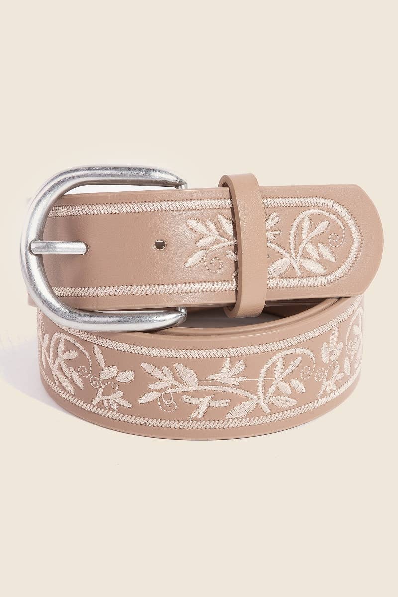 Beige belt with floral embroidery and silver buckle on a white background