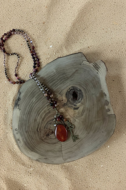 Orange  and red long beaded necklace with large stone and key pendants.
