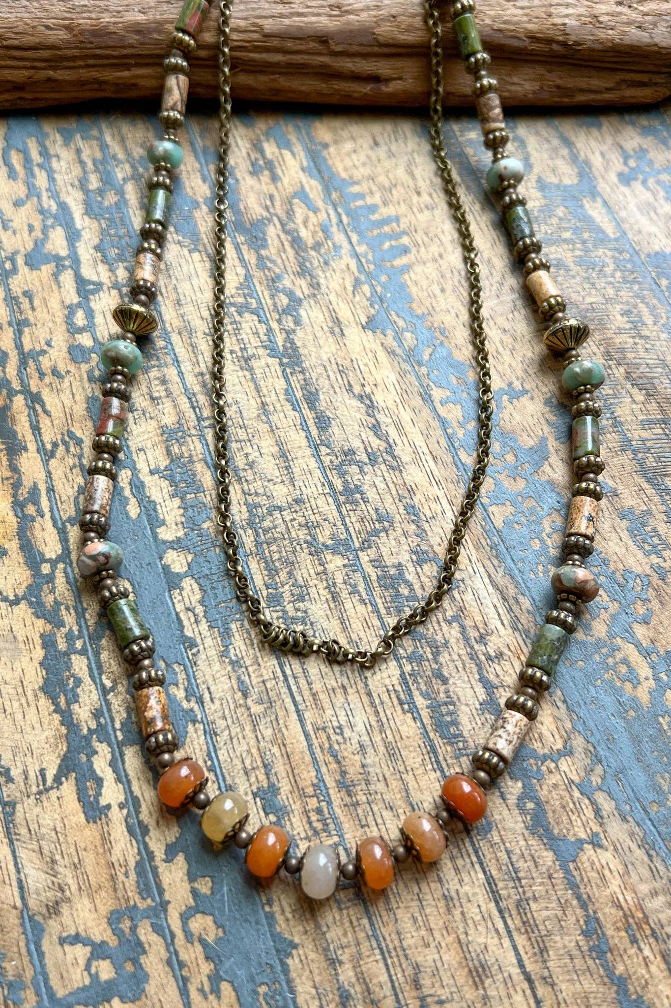 Beaded necklace with multicolored beads on a textured wooden surface