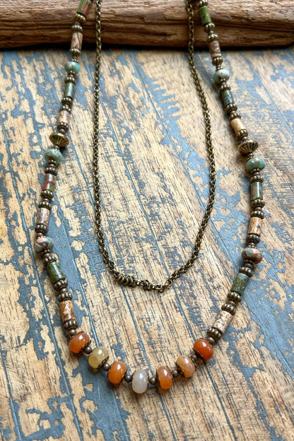 Beaded necklace with multicolored beads on a textured wooden surface