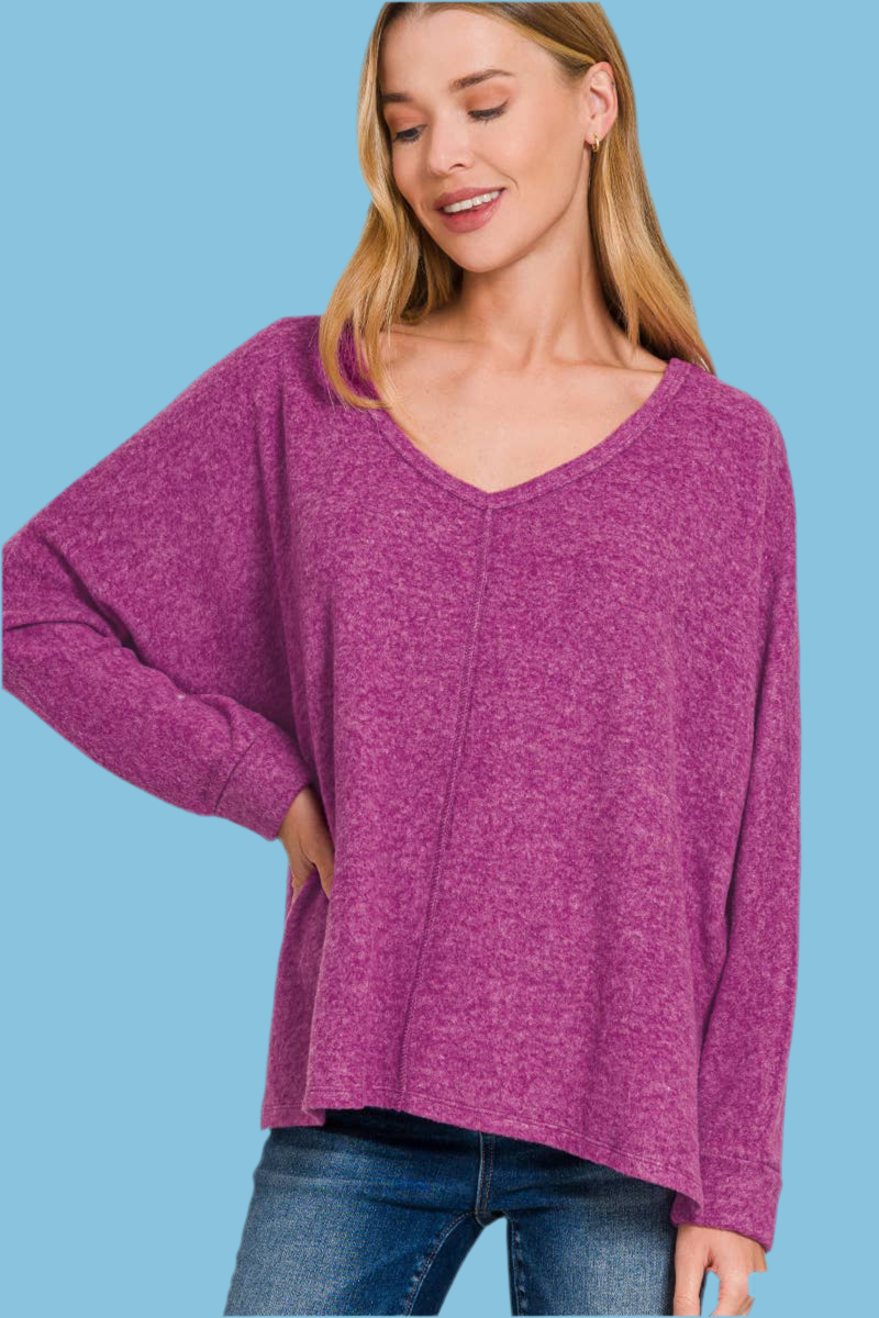 Woman wearing soft plum sweater with long sleeves and a v-neck