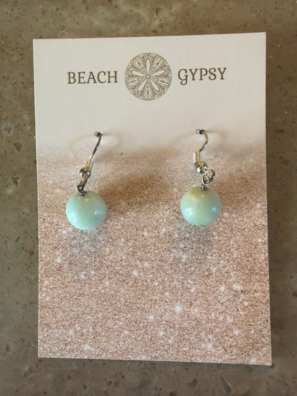 Pair of earrings with light green beads on a Beach Gypsy branded card.