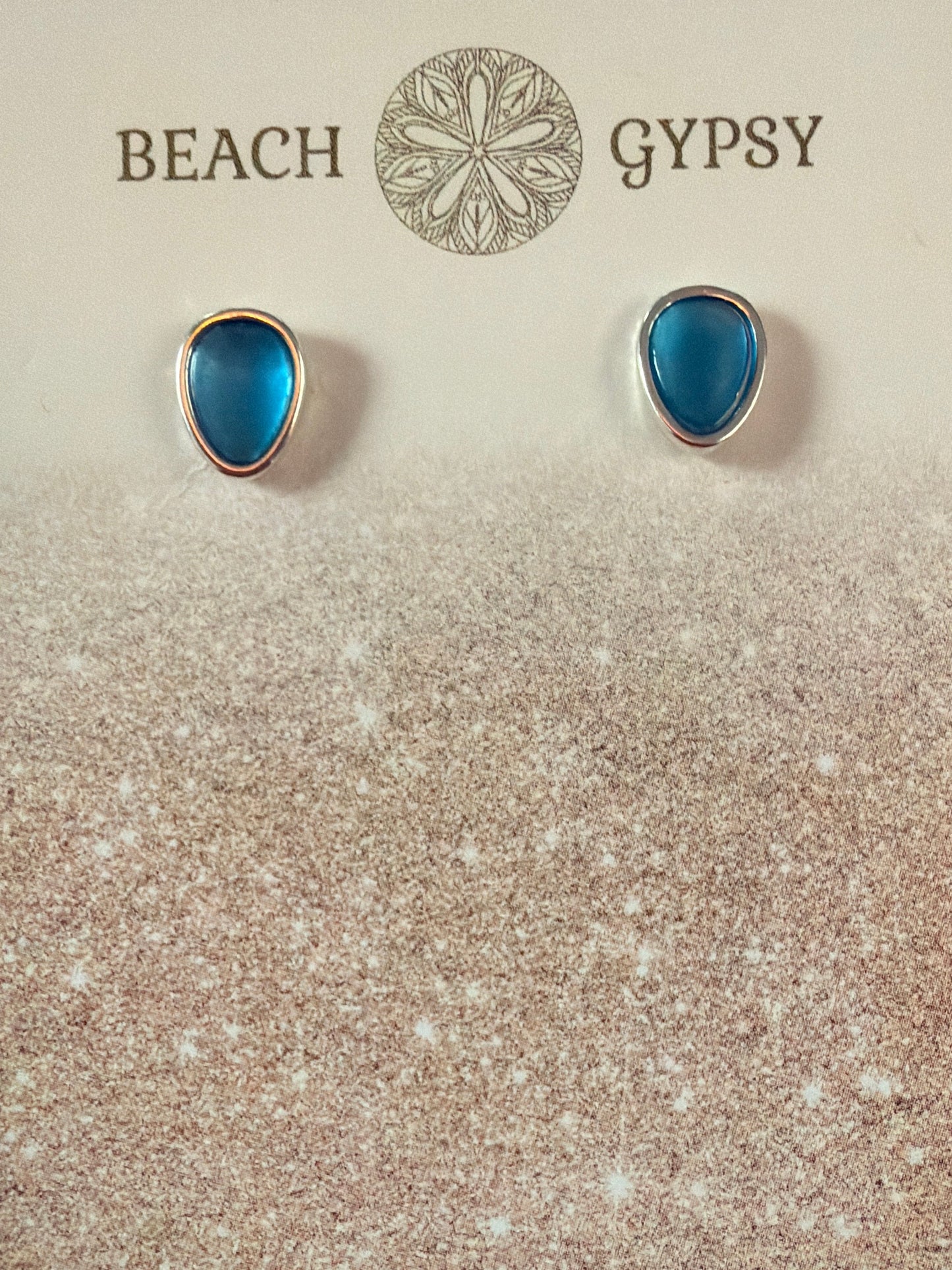Blue teardrop earrings on a 'Gypsy Beach' branded card with a purple background
