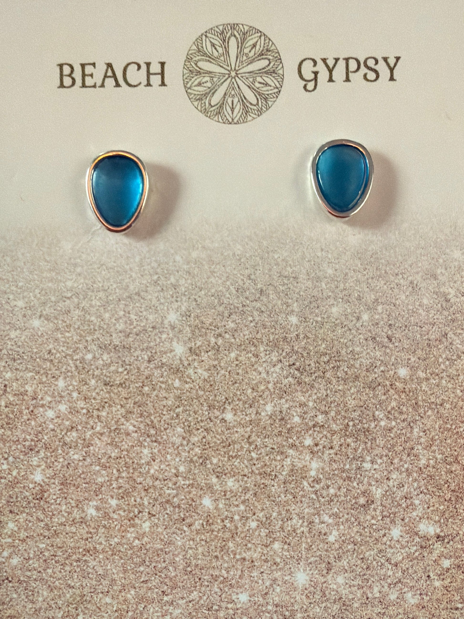 Blue teardrop earrings on a 'Gypsy Beach' branded card with a purple background