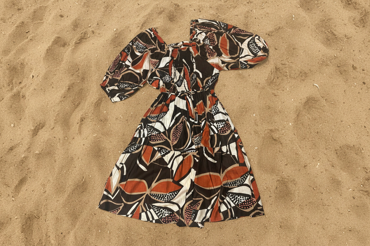 Cocoa Peasant Dress back view on top of sand 