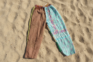 Colorful Patchwork pants on sand background 