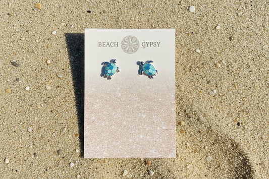 Turtle earrings on a 'Beach Gypsy' branded card against a pink background