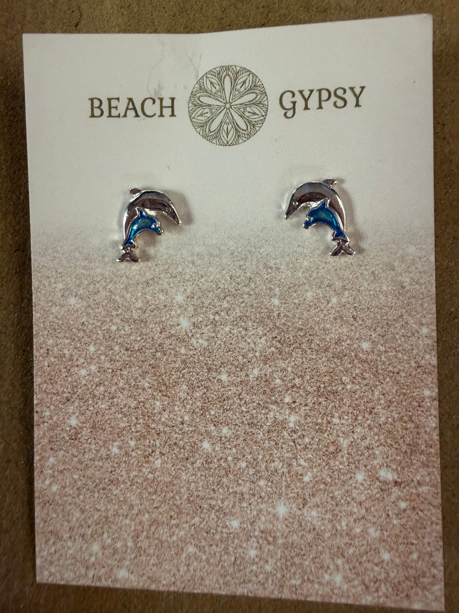 Dolphin-shaped earrings on a 'Gypsy Beach' branded card.