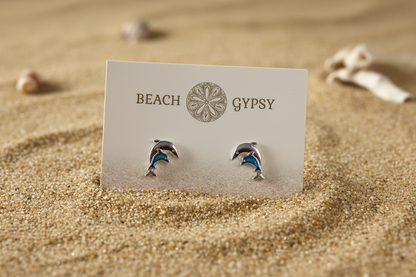 Double dolphin earrings on a beach