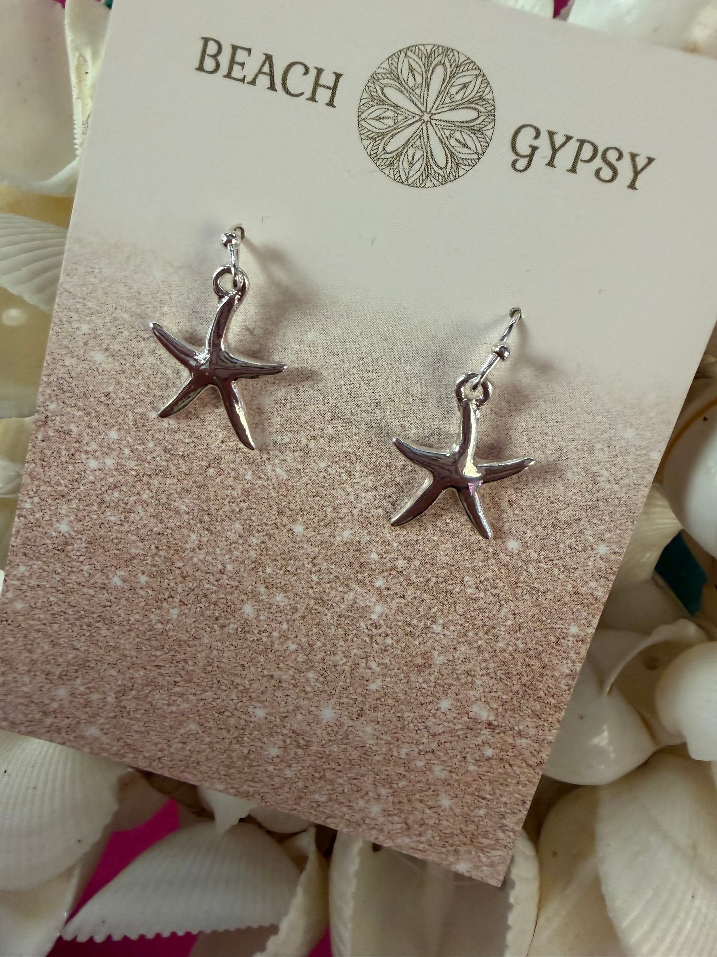 Starfish earrings on a 'Gypsy Beach' branded card with seashells in the background.