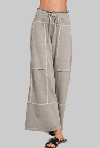 Gray wide-leg pants with white stripes on a gray background