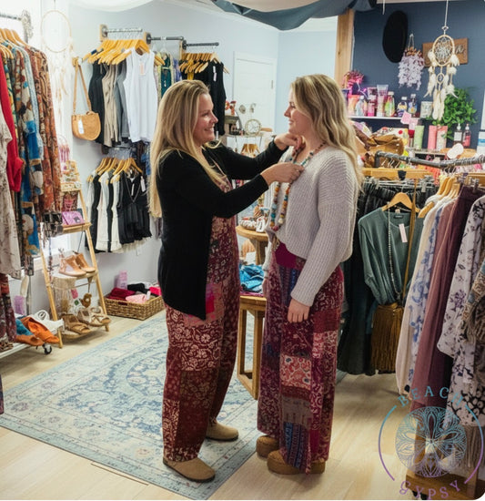 Two women in a clothing store trying on clothes