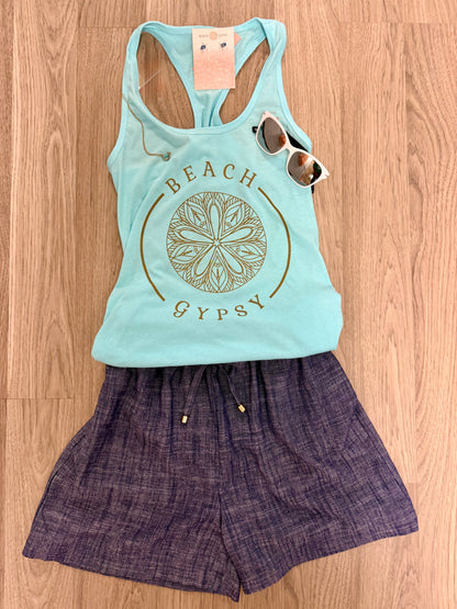 Light blue tank top with 'Beach Gypsy' design and denim shorts on a wooden surface