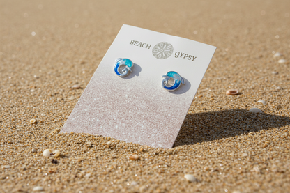 Blue and silver Dolphin wave earrings on Beach Gypsy branded earring card on beach 