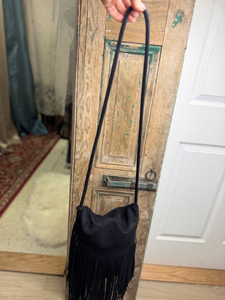 Black fringe crossbody handbag held up by its long strap to show the full length – Beach Gypsy