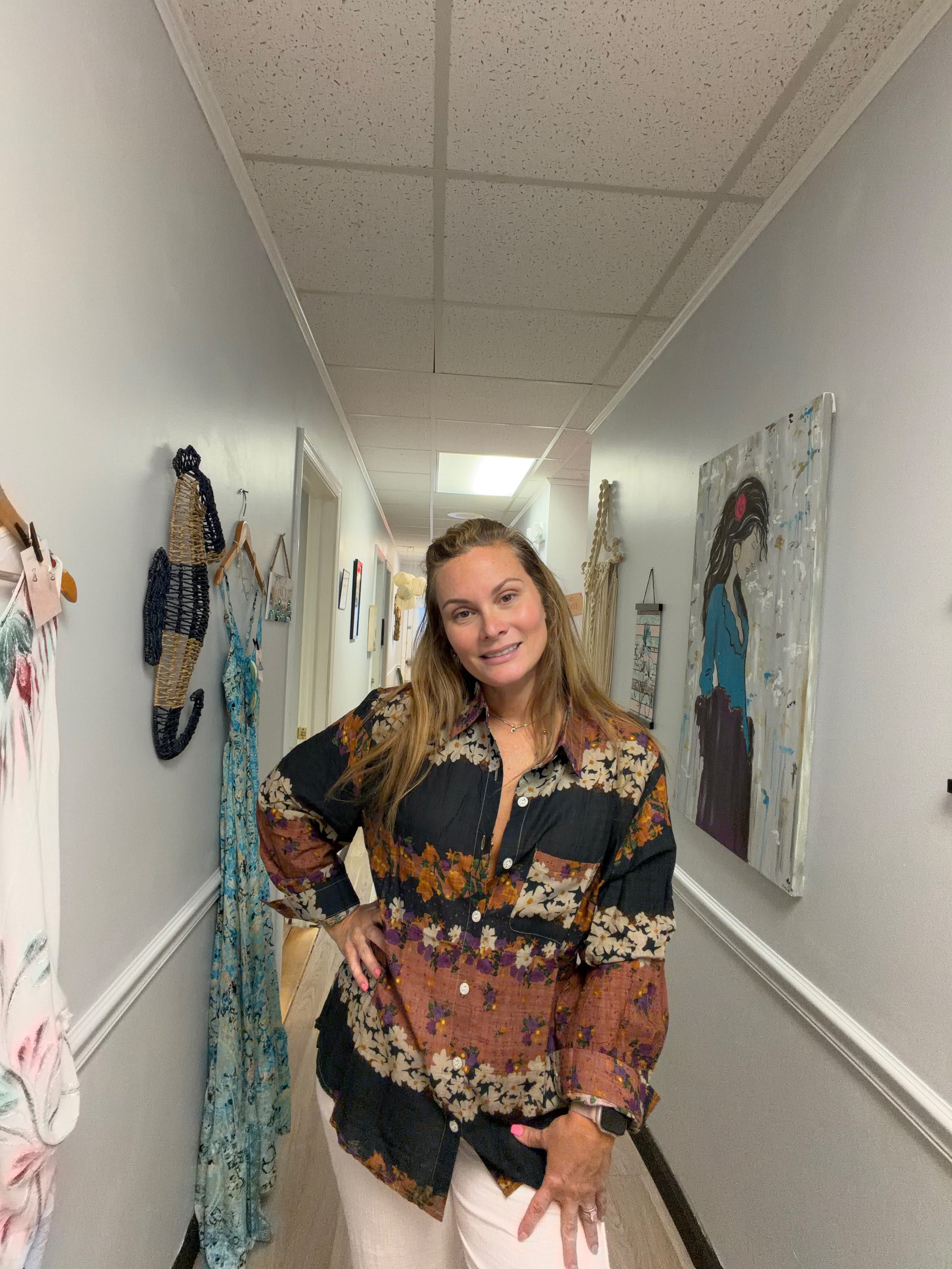 Woman standing in a hallway with artwork on the walls