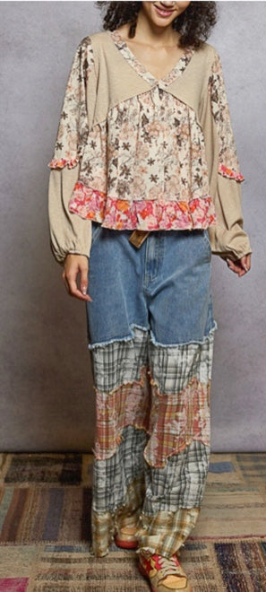 Person wearing a floral blouse and plaid pants against a gray background
