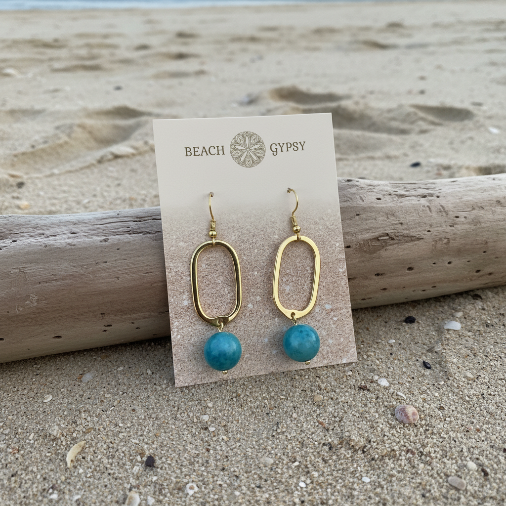 Blue sky stone earrings on gold dangle rectangular hook earring on beach background 