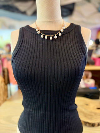  a delicate gold necklace featuring irregular white pearls