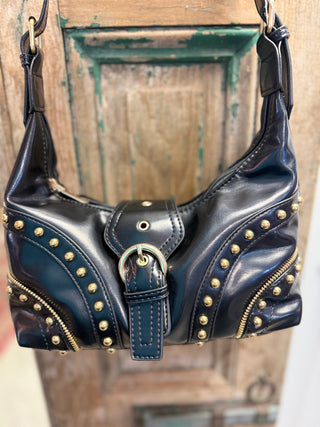 Front view of black studded shoulder bag with gold-tone stud trim and buckle strap accent – Beach Gypsy
