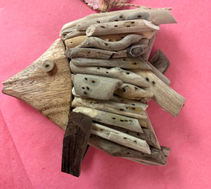 Driftwood fish sculpture ornament on a pink background in Berlin, MD near Ocean City, MD