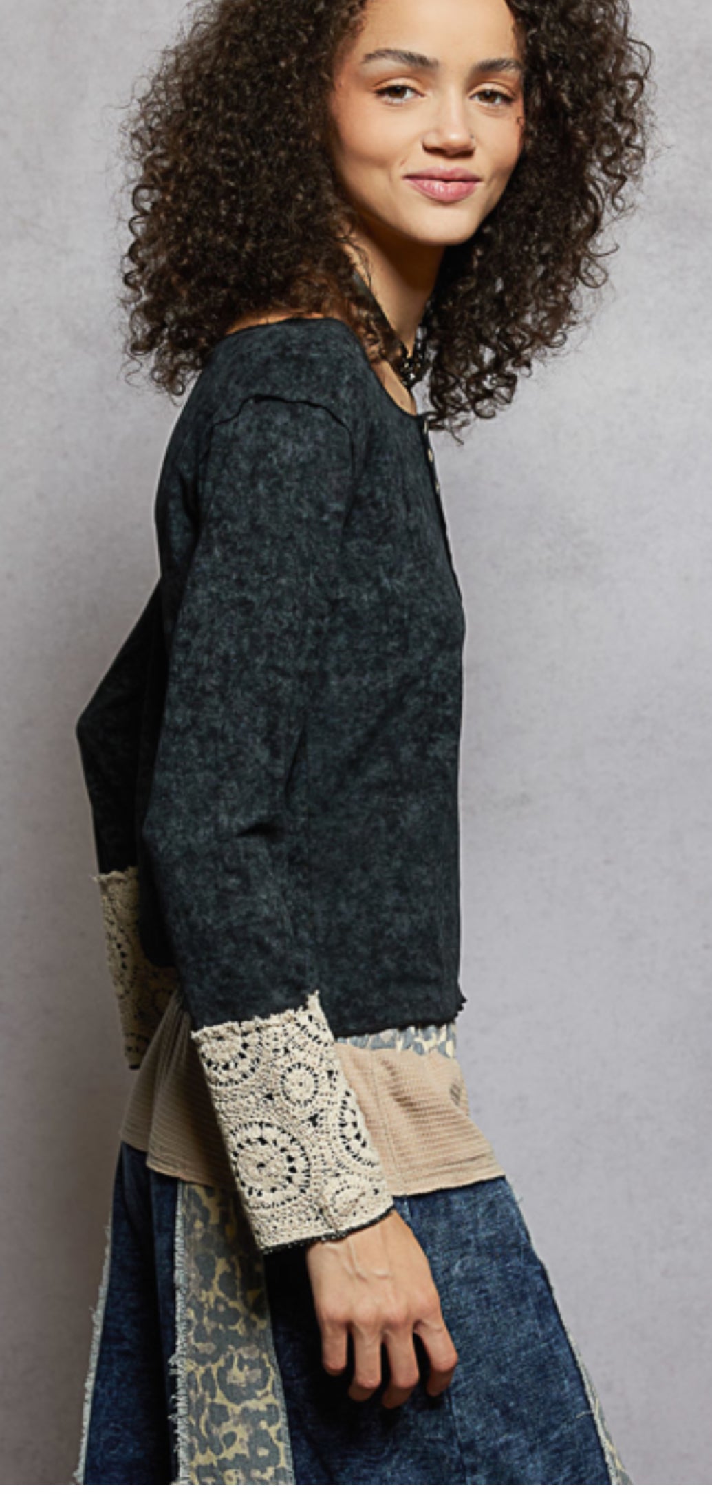 Black top with buttons and lace sleeve cuffs side view