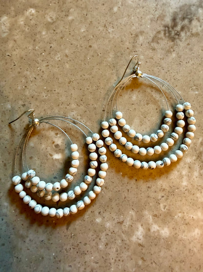 White turquoise beaded earrings on marble surface