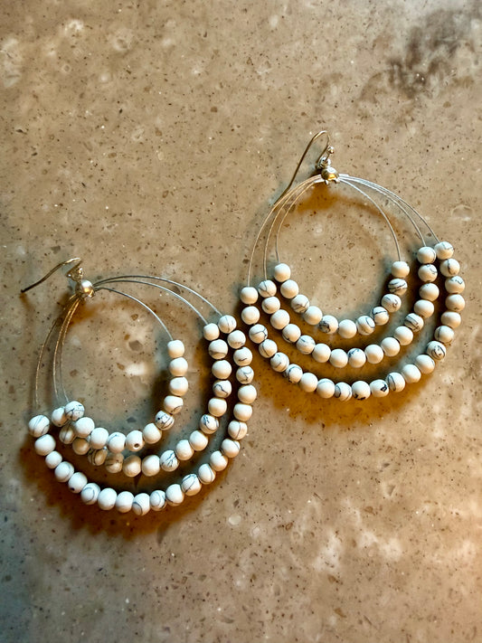 White turquoise beaded earrings on marble surface