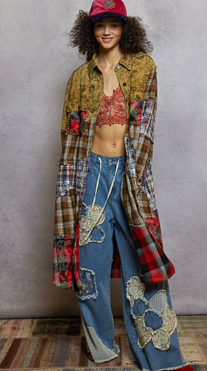 Model wearing a patchwork outfit with a plaid shirt and jeans against a gray background