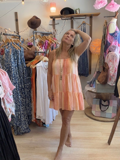 Woman wearing a peach colored dress in a Beach Gypsy clothing store
