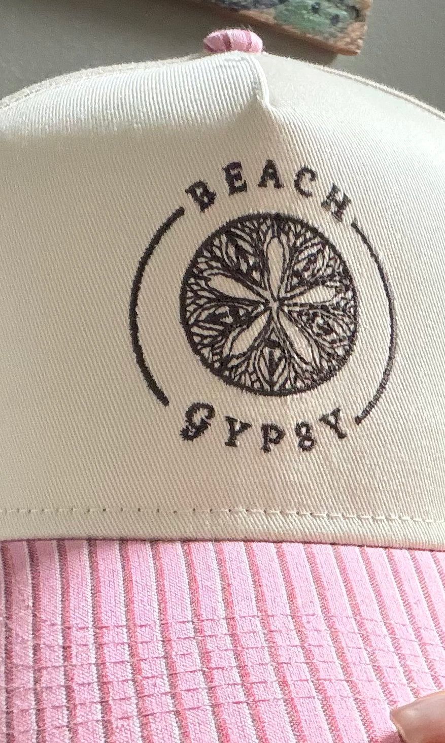 Beach Gypsy logo on a pink striped brim of a canvas trucker hat