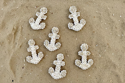 Decorative anchors with seashell details on a pink background