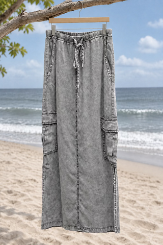 A light gray washed denim midi skirt with an elastic drawstring waist, side pockets, and cargo pocket details.