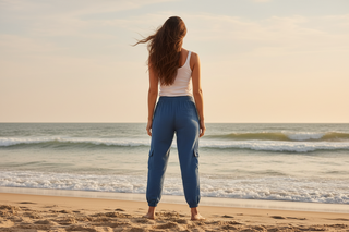 Back view of woman wearing navy cargo pants on a beach