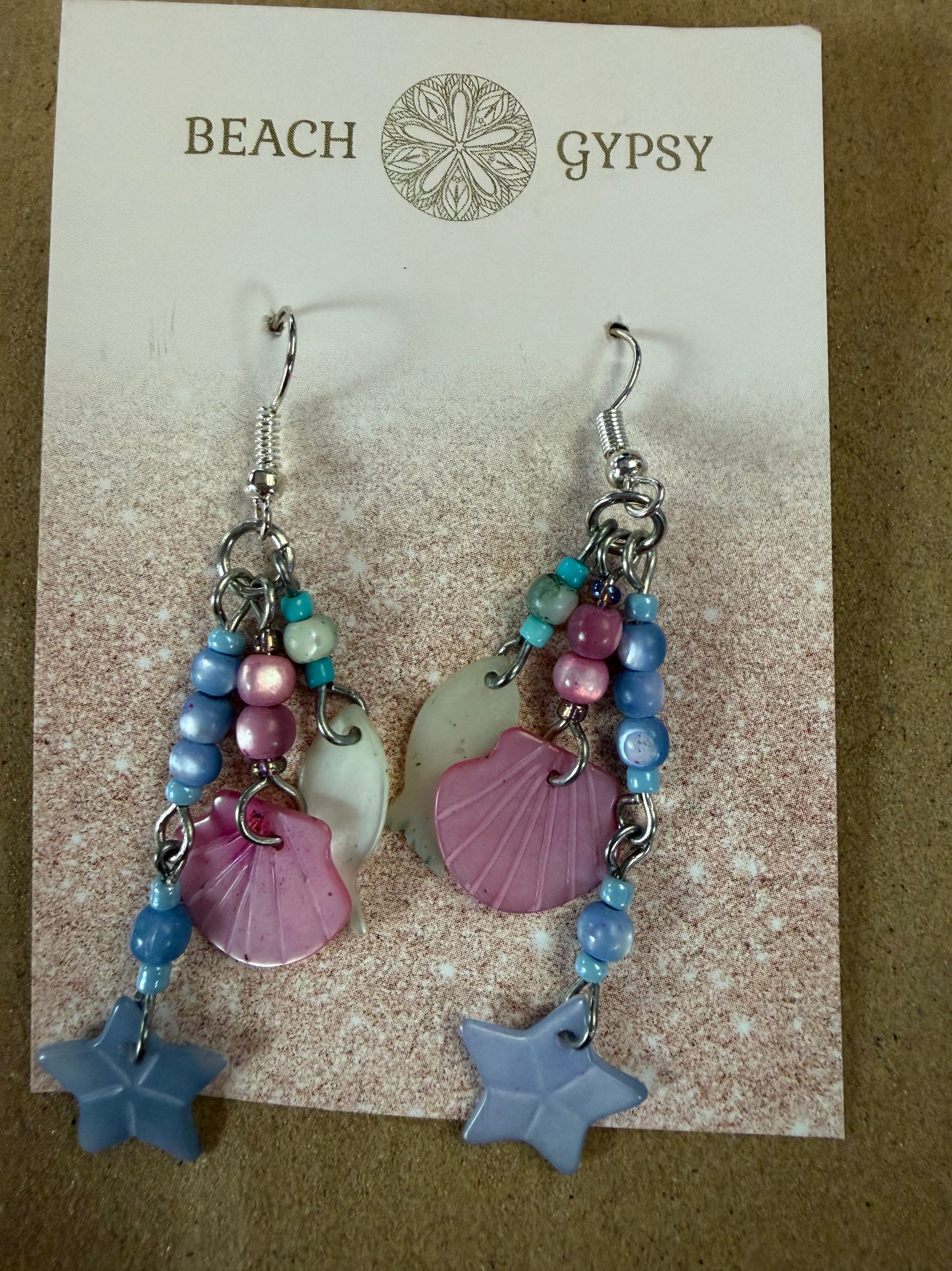 Beach Gypsy earrings with seashells and beads on a branded card.