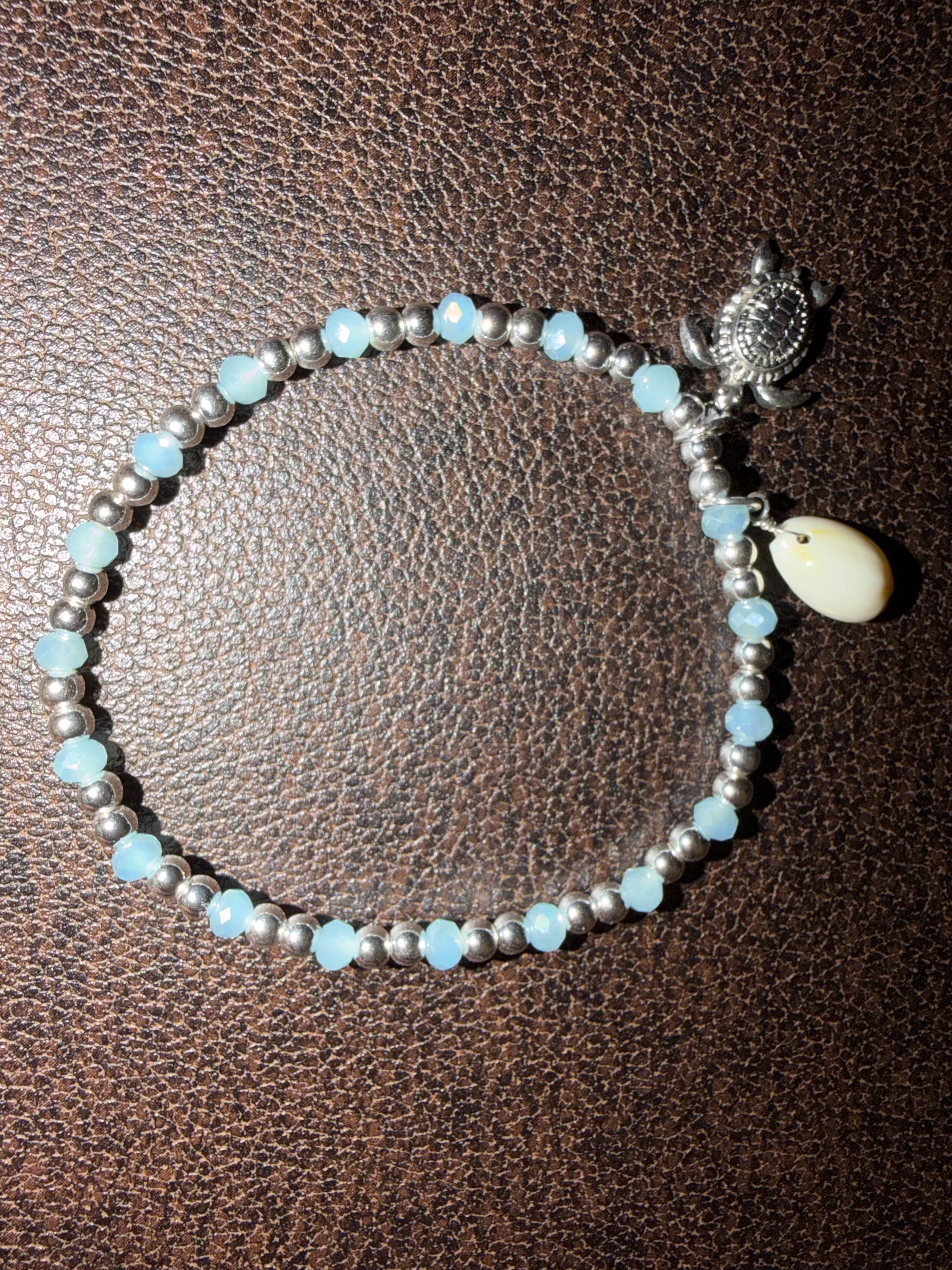 Bracelet with blue and silver beads on a brown textured background