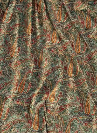 Green paisley Patterned fabric on a sandy surface