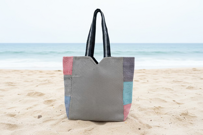 Natural hemp bags with colorful patterns on sand