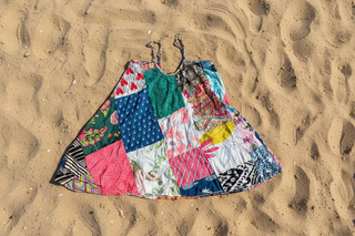 Colorful patchwork dress on sand
