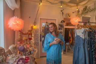 Woman wearing lace fringed kimono standing in a beautiful Beach Gypsy boutique