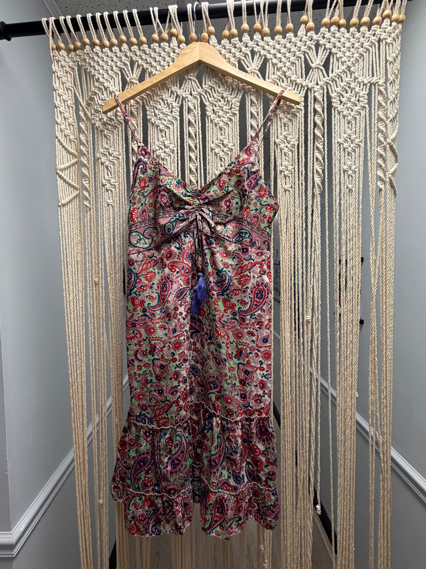 Floral dress on a hanger against a wooden floor background