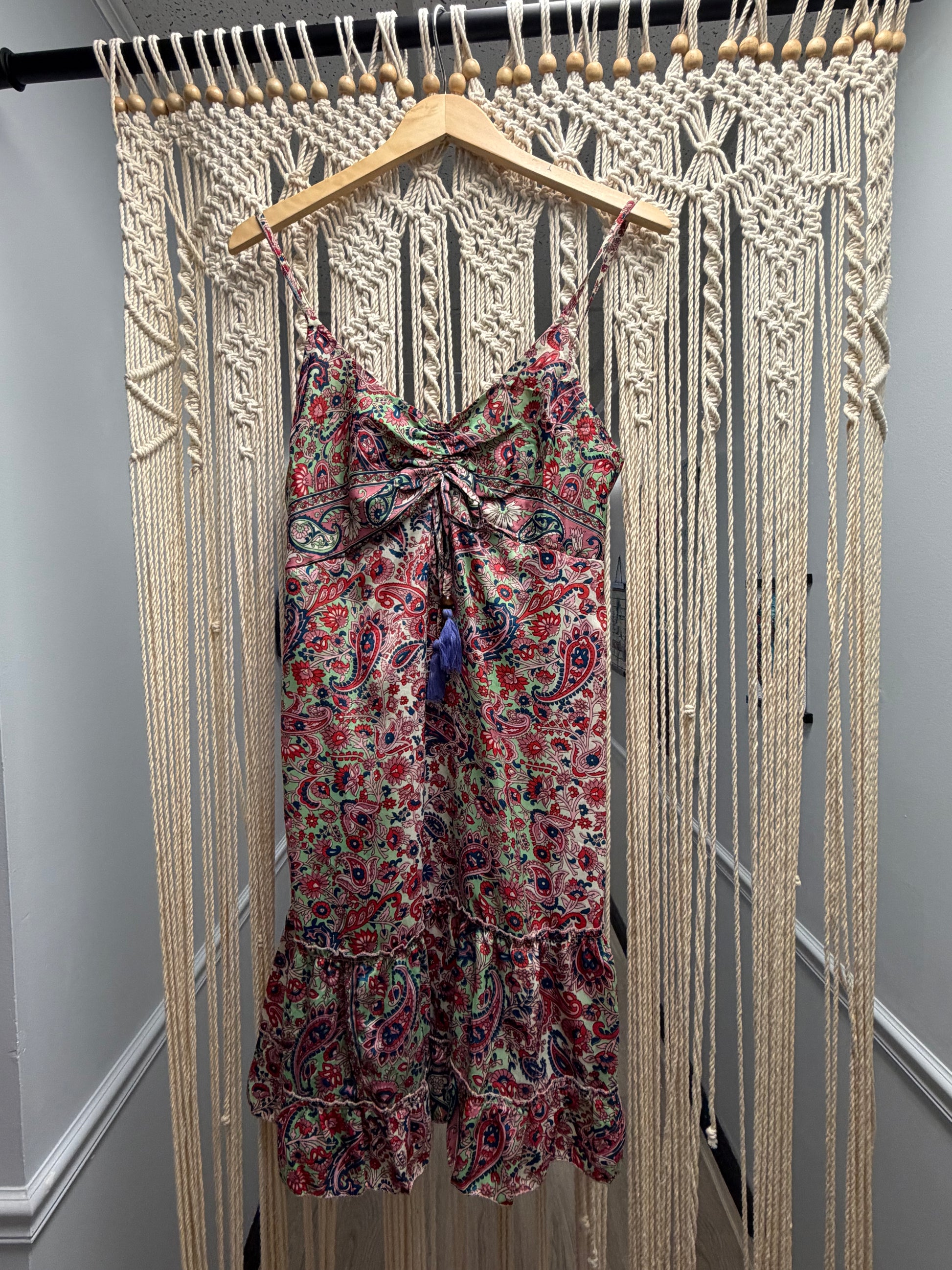 Floral dress on a hanger against a wooden floor background