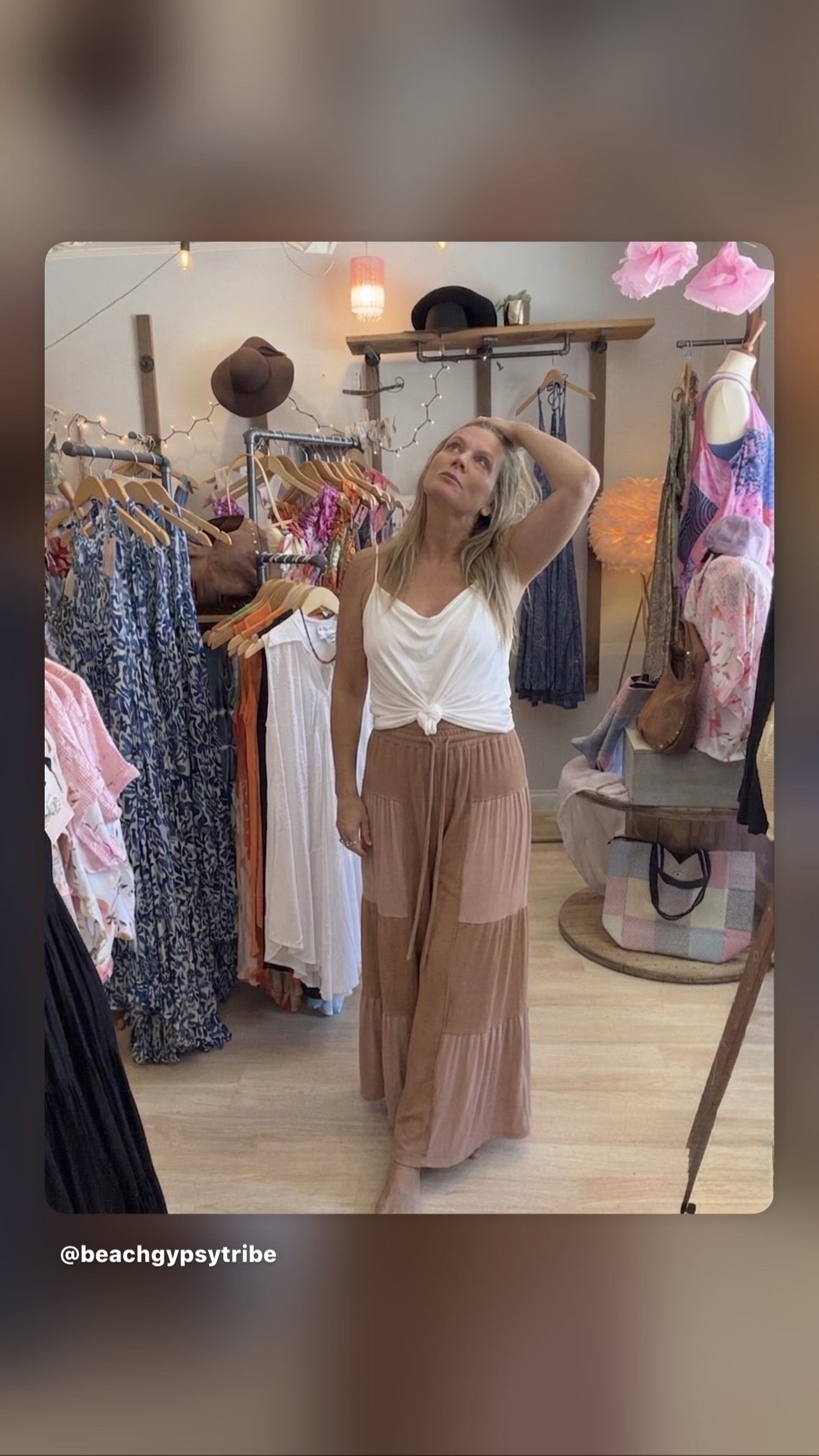 woman wearing chocolate colored patch  flowy pants and white top