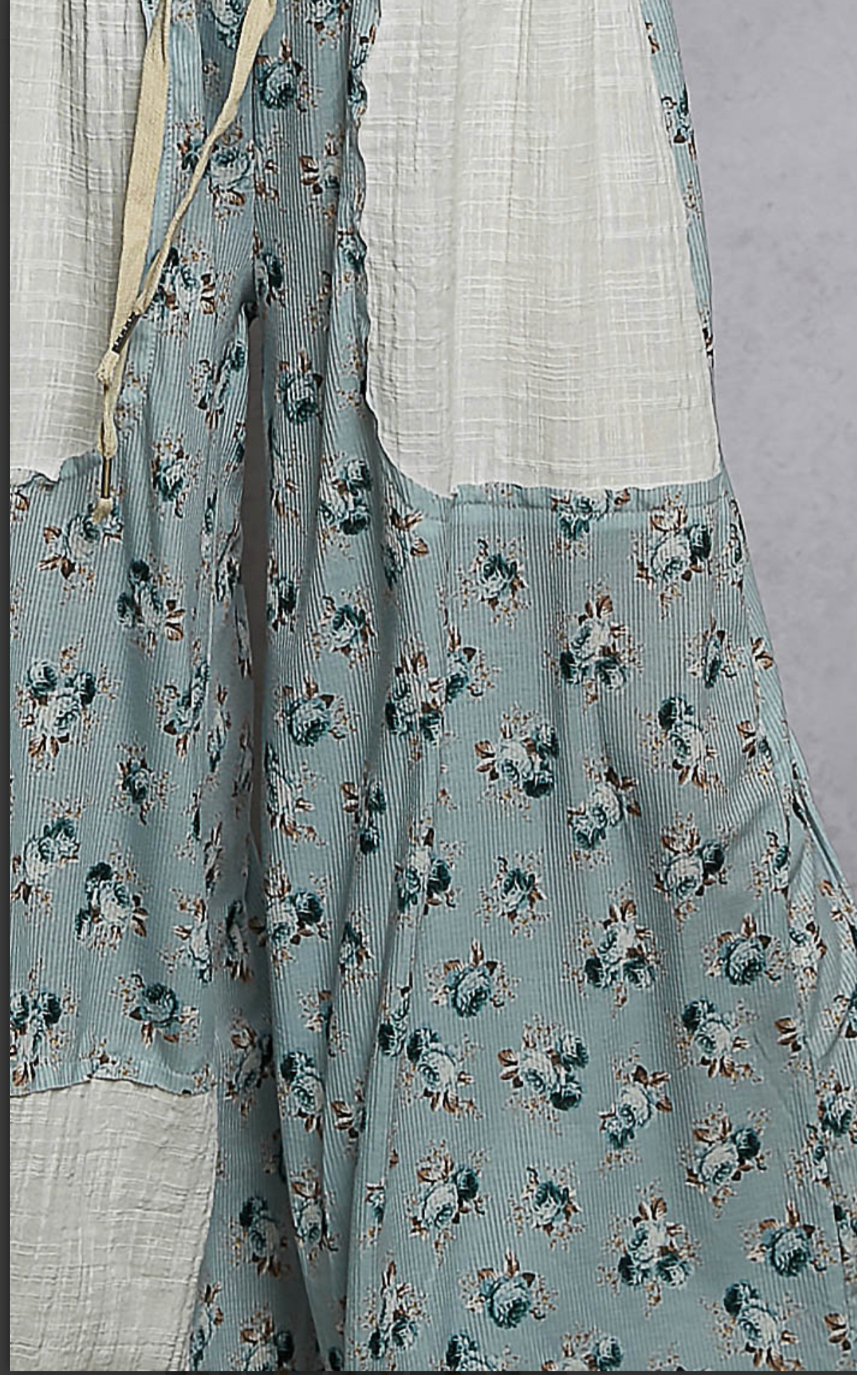 Closeup of fabric for blue floral flowing pants with cream patches 