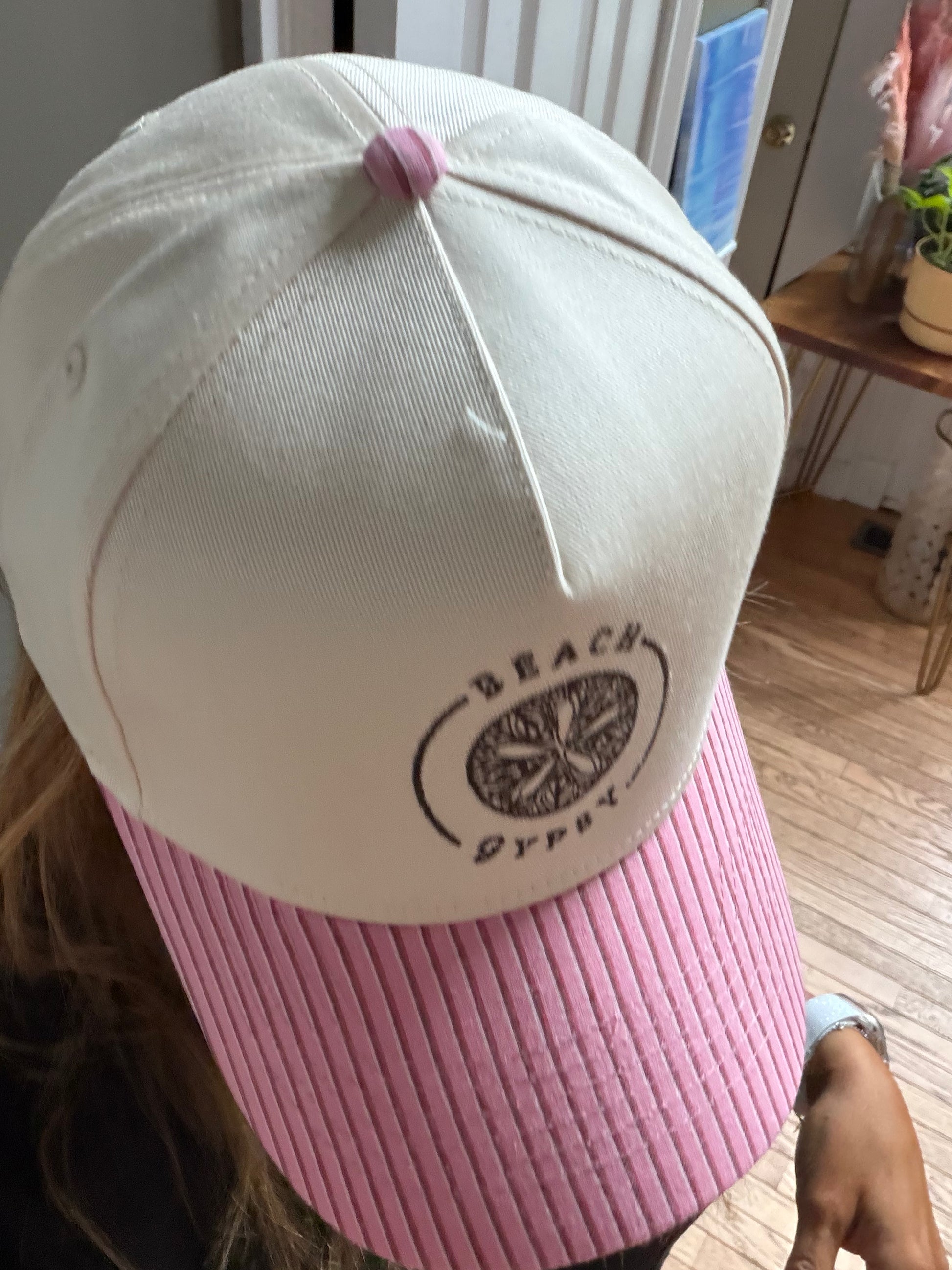 Beautiful woman showing a pink striped brim on a  canvas Beach Gypsy trucker hat
