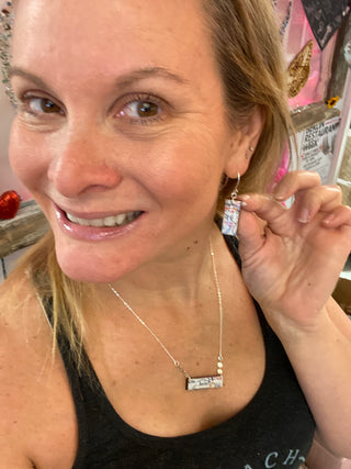 Smiling woman wearing Custom made map of Berlin Earrings & Necklace.  Sterling silver.