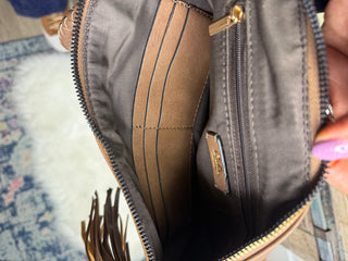 Close-up of fringe wristlet bag interior  with card slots and zippered pocket