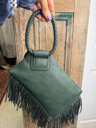 Olive green fringe wristlet bag held by its braided ring handle to show size