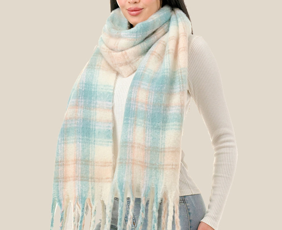 Woman wearing a plaid scarf with pastel colors on a plain background